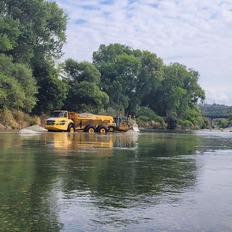 A dump trucks delivers gravel to a section of the Feather River in Oroville to improve the salmon spawning habitat.