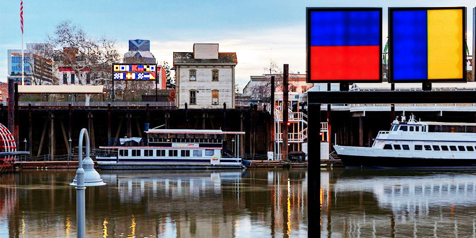 Boats on a river with nautical flags displayed