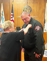 A woman pins a badge on a new fire chief