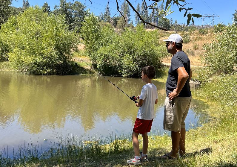 two people fishing at pond