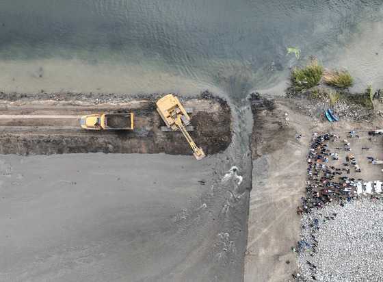 Aerial shot of a levee being breached intentionally for a habitat restoration project