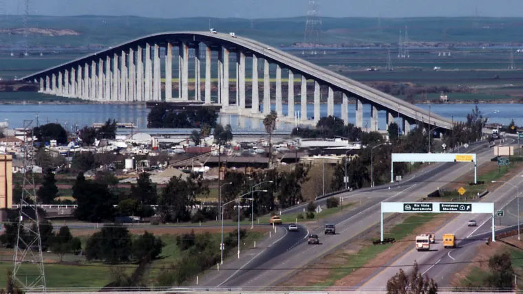 A tall bridge arches over a river