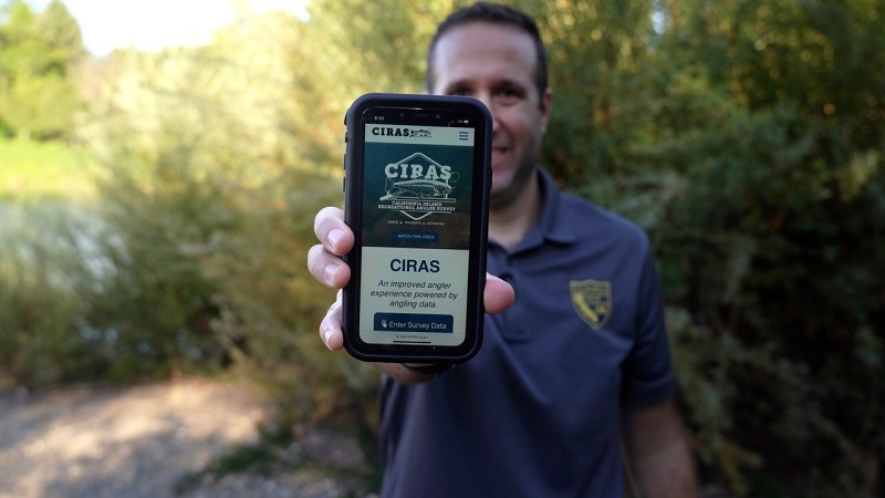 CDFW staffer holds up a cell phone to show the CIRAS web pages.