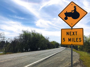 A roadsign warns of agricultural equipment next five miles