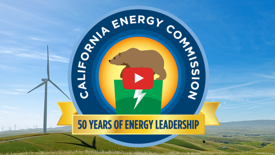 California Energy Commission, 50 Years of Energy Leadership seal in the middle with a background of a grassy field and wind turbines.
