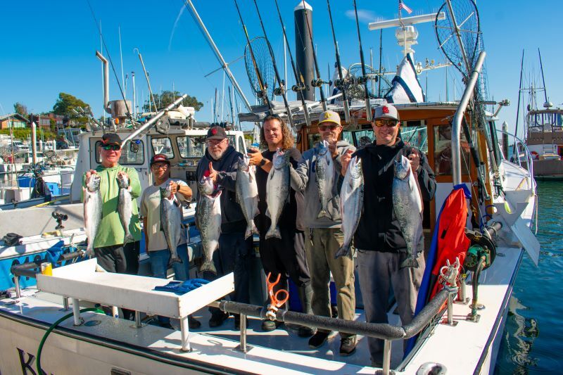 A group each holding up a salmon. 