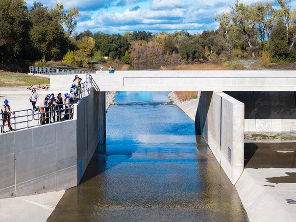 People standing on a concrete overlook of a waterway