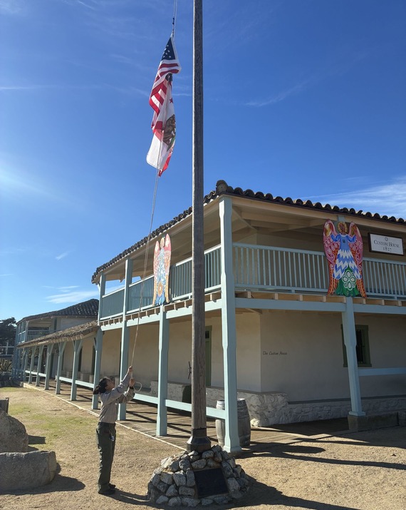 Monterey State Historic Park  Guide Trainee raises the colors at the Custom House flag