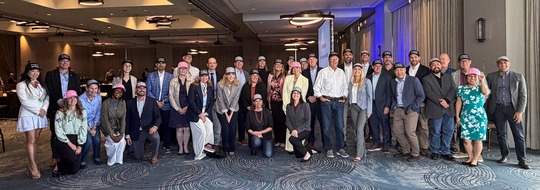 Team in group photo wearing baseball hats