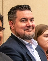 A man in a suit smiling
