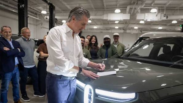 Man signs paper on car