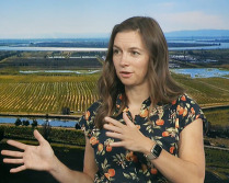 Woman gesturing with aerial image of delta in background