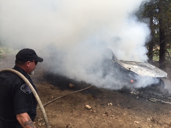 Deputy Joe Menger helps fight vehicle fire in Gordon Gulch