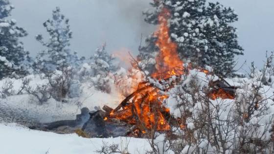Burning wood pile in snow