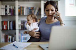 Woman and baby on the phone getting help line assistance.