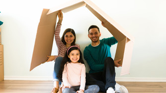 Family with a cardboard home over their heads