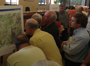group of people examining a map of Boulder County
