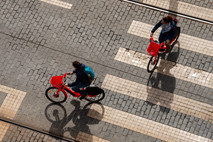 Two people on bikes crossing the street