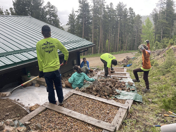 Teenagers perform wildfire mitigation work at a house in the forest