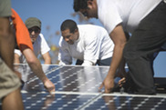 men installing solar panels on a roof
