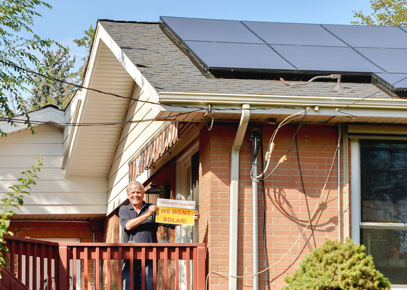 A Broomfield, CO Solar Co-op member stands in front of his newly installed rooftop solar system.