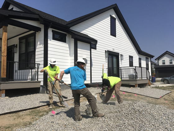 Crews from TEENS, Inc. help build a noncombustible gravel barrier for a family who rebuilding their new home in the Marshall Fire burn area.