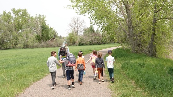 Volunteer Naturalist leading a group of second-grade students on a trail during a wetlands field trip at Pella Crossing