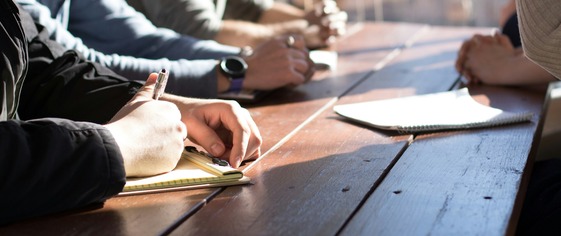 group of people taking notes in a meeting 