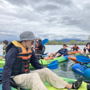 a group of youth in kayaks on the water