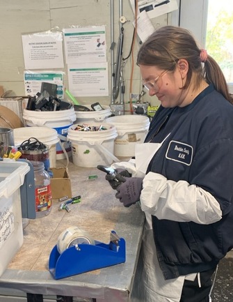  hazardous materials specialist taping batteries with clear tape