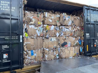 bales of cardboard stacked in a rail car