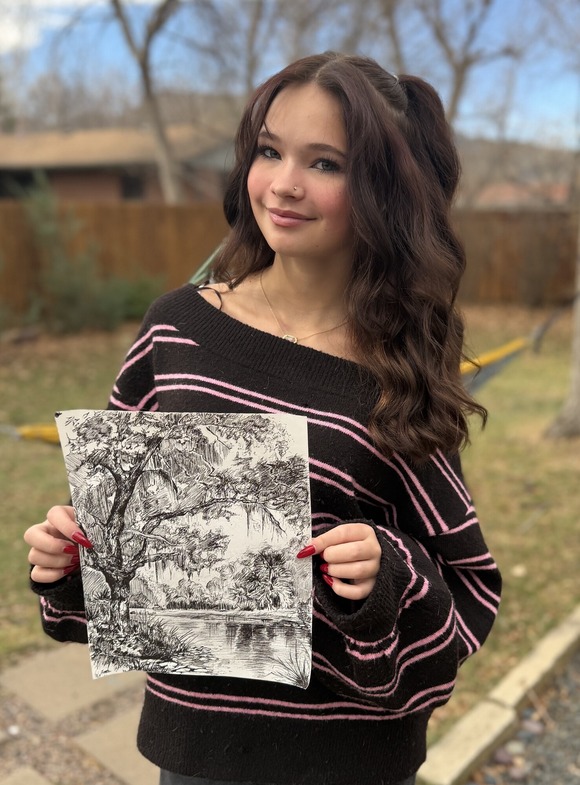 6-8 Grade First Place Winner Zara with her art, a back and white ink illustration of a pond scene with a large tree