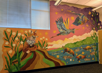 Painted mural that goes from floor to ceiling. There is a fox, two blue herons, several turtles and fish