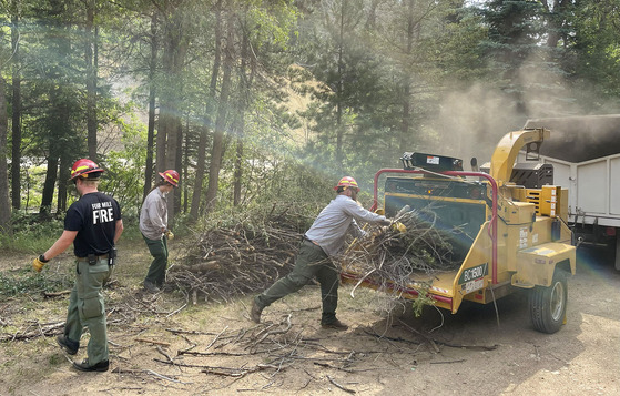 Wildfire mitigation wood chipping crew at work in a wooded area