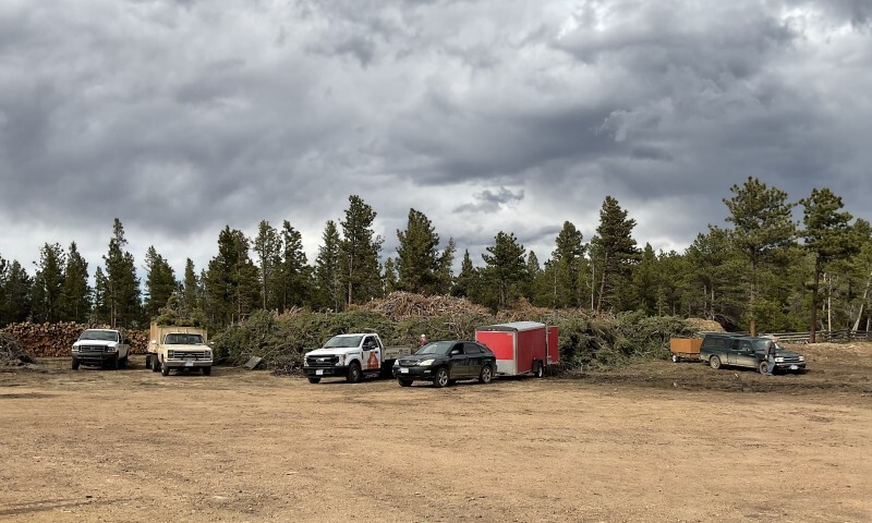 People unload woody material from their vehicles at the Nederland Sort Yard
