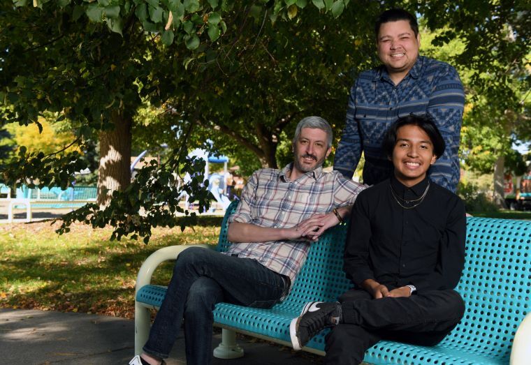 Picture of two Dads, Eric and Teddy, with their adult son Gabe.