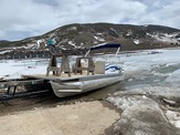 pontoon boat breaking the ice on the reservoir 