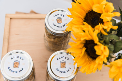 Cookie jar next to sunflowers on a table 