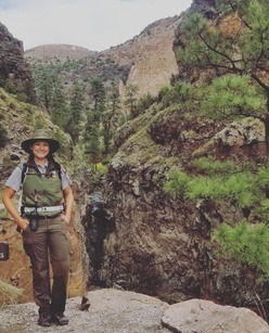Park Ranger standing next to a waterfall 