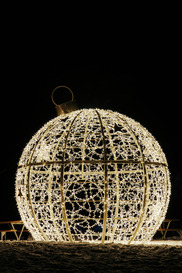 A prominent white egg-shaped building adorned with lights, showcasing a unique architectural design.