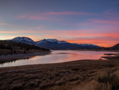 Sunset over a body of water with mountains in the background 