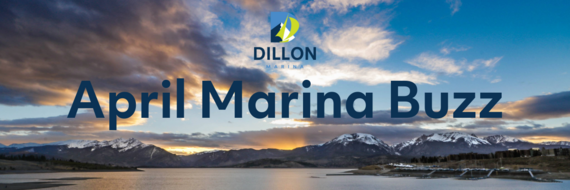 A lively marina in April, with various boats moored and spring flowers adding color to the picturesque view.