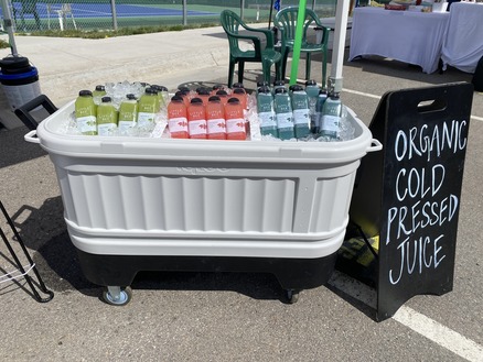 A white cart displaying a sign, positioned in a bright, open area.