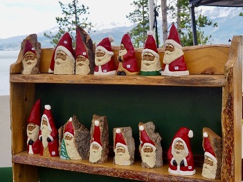 Santa Claus figure intricately carved from logs, showcasing detailed facial features and traditional red attire
