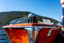 A close-up image of a boat with a man standing aboard, highlighting the vessel's details against the water
