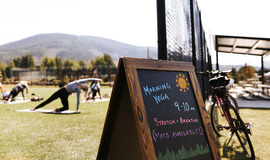 A chalkboard displaying a sign that reads "summer yoga," inviting participants to join the seasonal classes