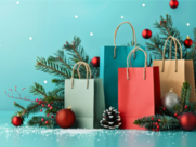 Colorful Christmas shopping bags and festive decorations arranged on a blue background.
