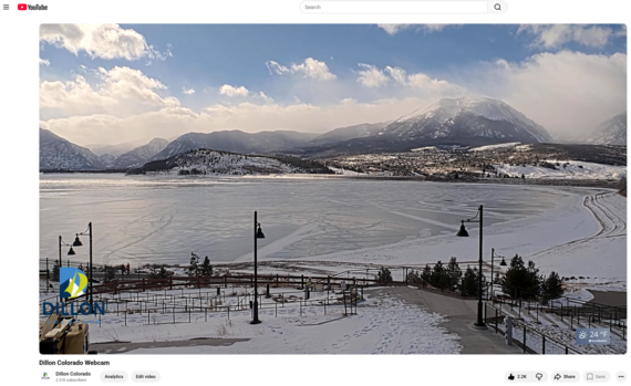 Frozen Dillon Reservoir with snow-covered mountains and a lakeside walkway in Dillon, Colorado.