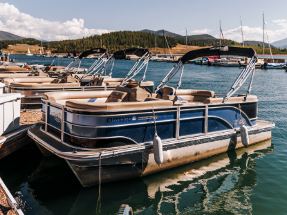 A pontoon boat docked in a scenic marina 