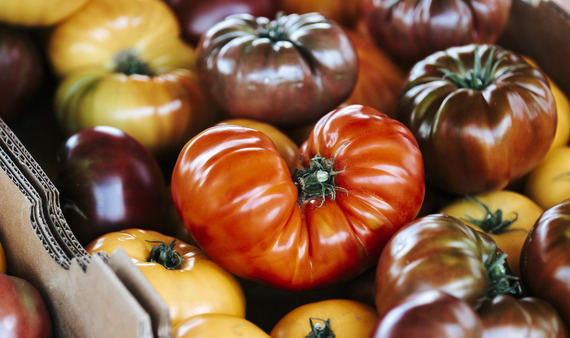 a colorful red tomato sits on top of more tomatoes at the Dillon Farmers Market